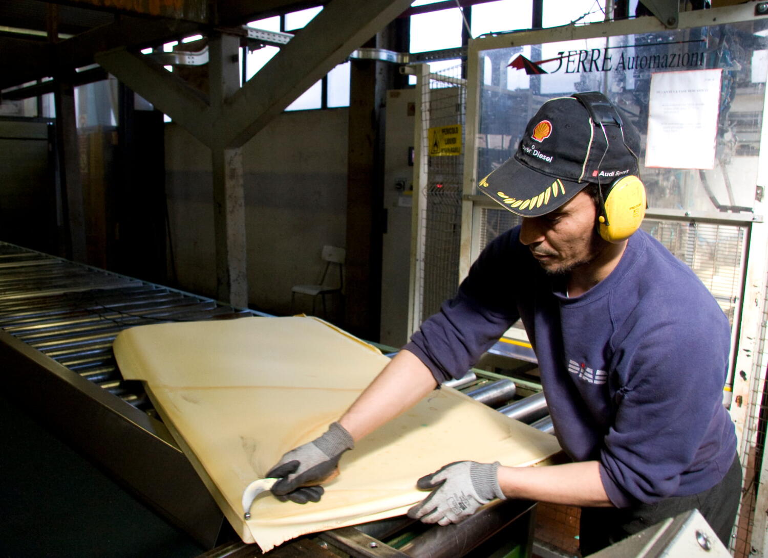 Workers cutting materials at the Diab factory, which specializes in core materials for composite materials (sandwich technology) for industries such as marine, wind energy, and aviation.