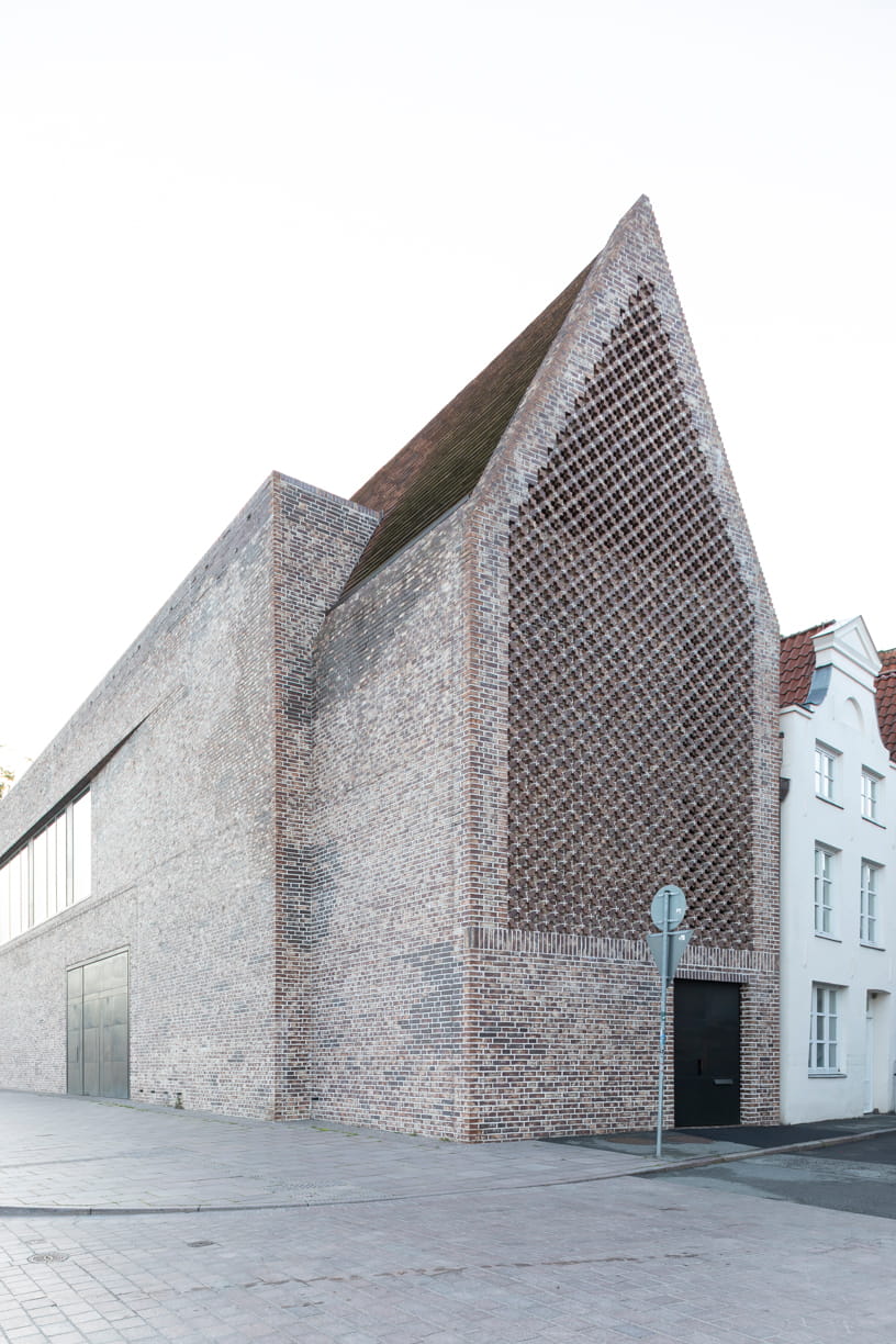 Side view of the red brick façade of the European Hanseatic Museum by Andreas Heller Architects in Lubeck.