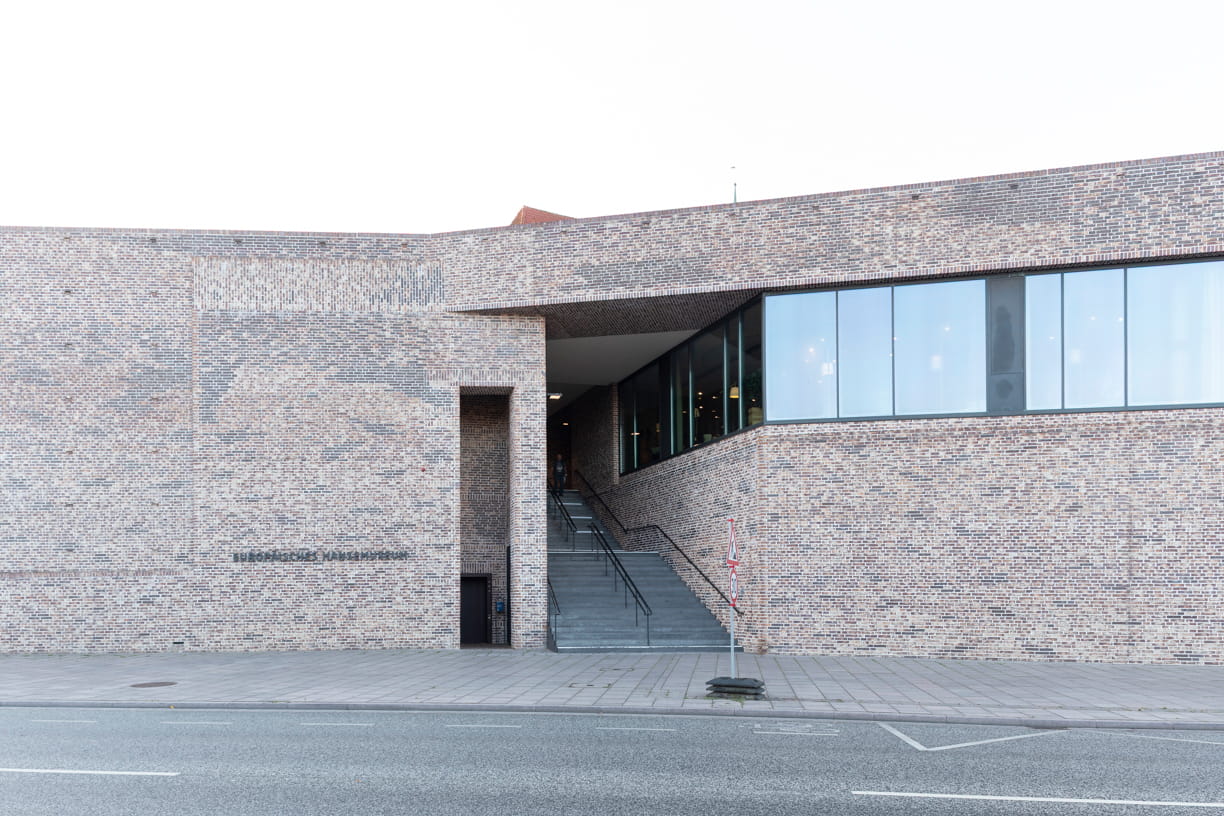 View from the street of the red brick façade and staircase of the European Hanseatic Museum by Andreas Heller Architects in Lubeck.
