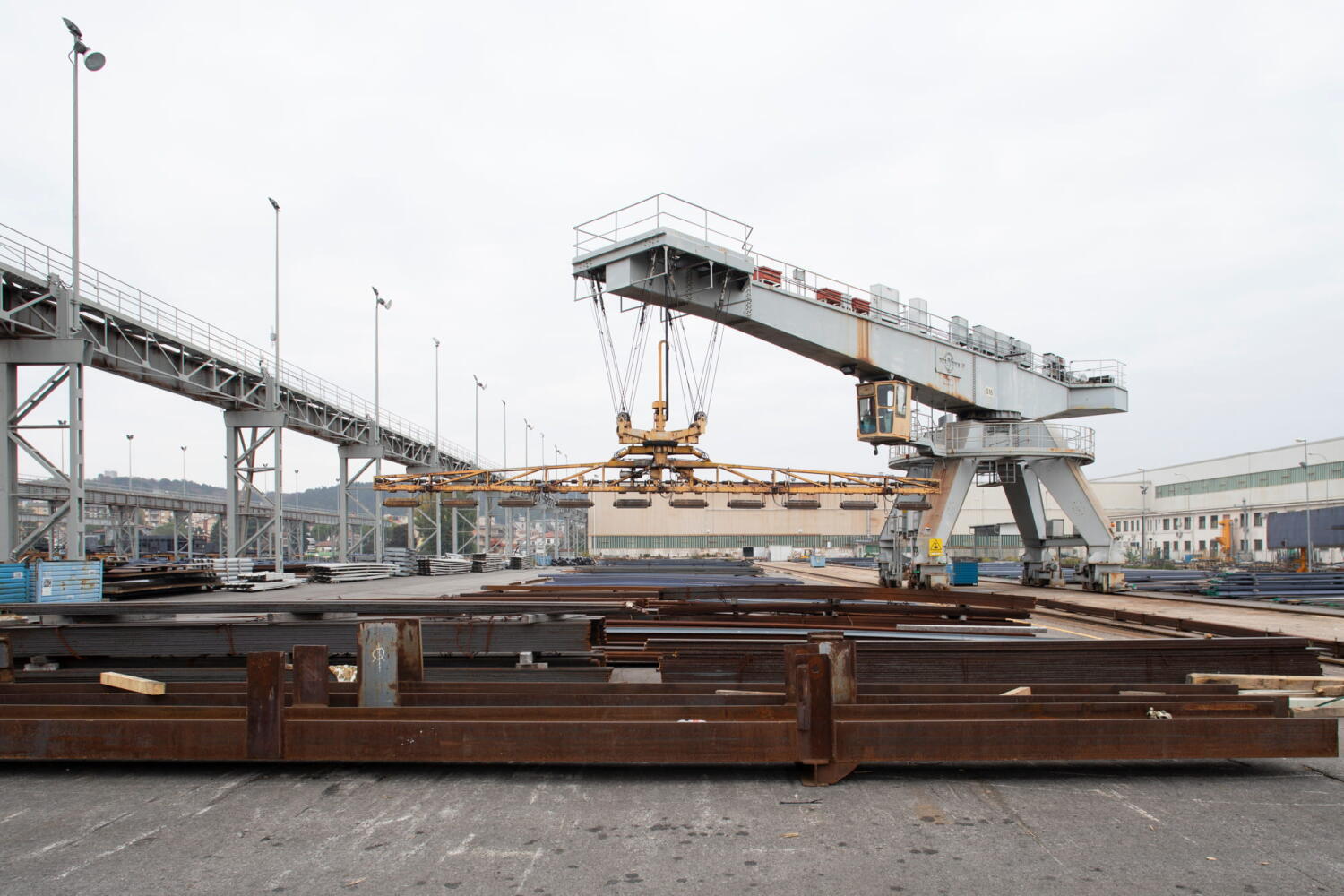 Overhead crane transporting metal components at the Fincantieri shipyard in Monfalcone, Italy.