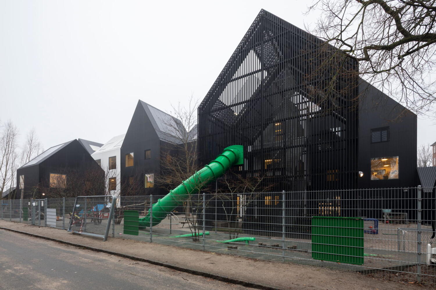 Green slide at Frederiksvej Kindergarten by Cobe Architects in Copenhagen.