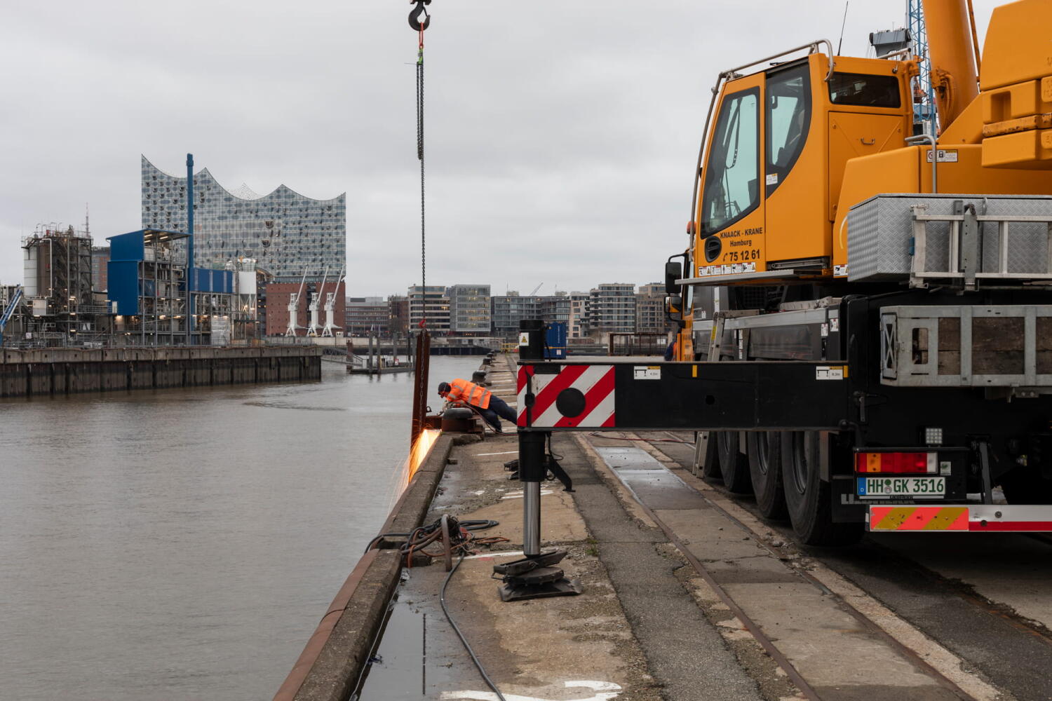 Workers using welding torches on the quay of the Port of Hamburg.